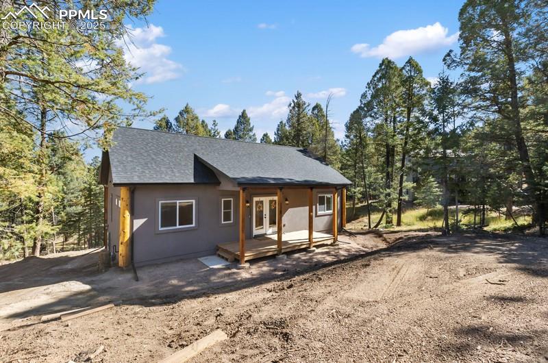 Image 34 of 37: View of front facade featuring roof with shingles, French doors, and covere