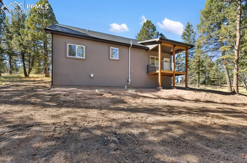 Image 37 of 37: Rear view of property featuring stucco siding and a deck