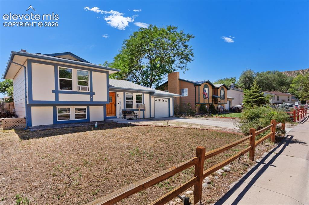 Image 1 of 36: Split-level home featuring a two-tone exterior, an attached single-car gara