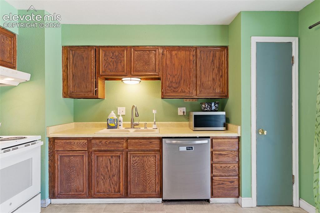 Image 12 of 36: Efficient kitchenette featuring warm wood cabinetry with ample storage, lam