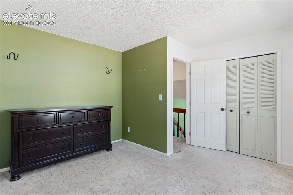 Image 16 of 36: Spacious bedroom offering fresh two-tone paint finishes with soft sage-gree
