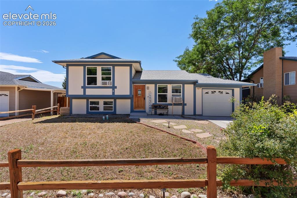 Image 2 of 36: Split-level residence featuring a two-tone exterior, an attached single-car