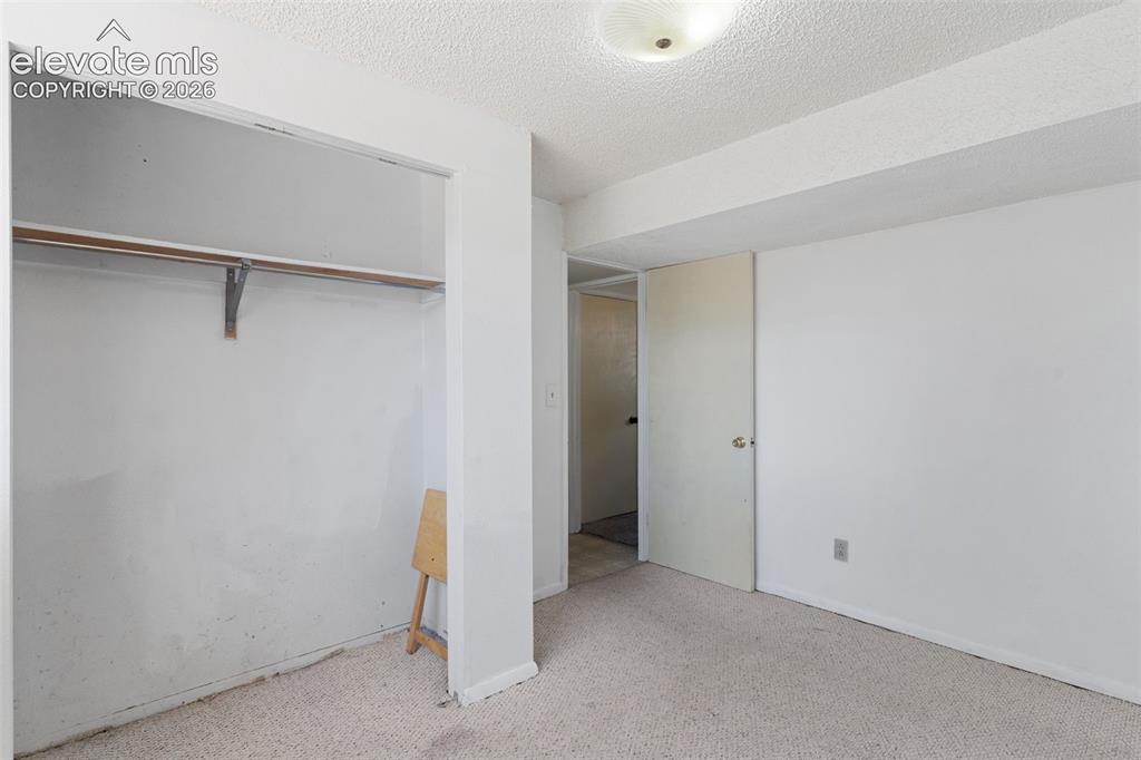 Image 29 of 36: Carpeted interior space featuring a recessed closet with a clothes rod