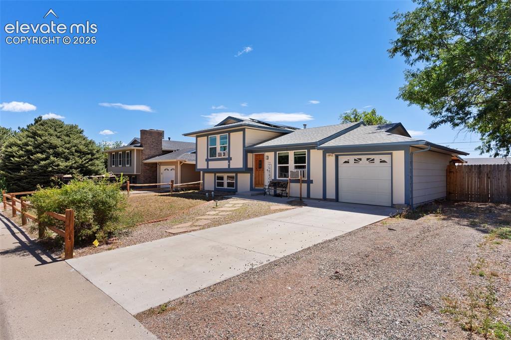 Image 3 of 36: Split-level residence featuring a two-tone exterior, a concrete driveway, a