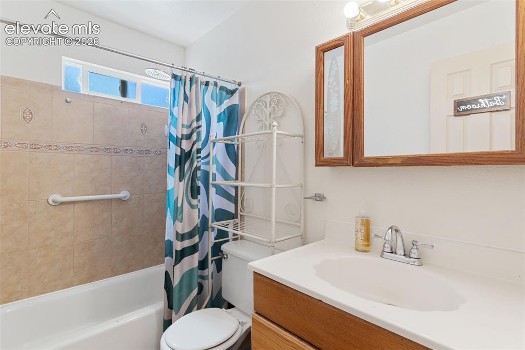 Image 31 of 36: Bathroom vanity with a white countertop and integrated sink, chrome faucet,
