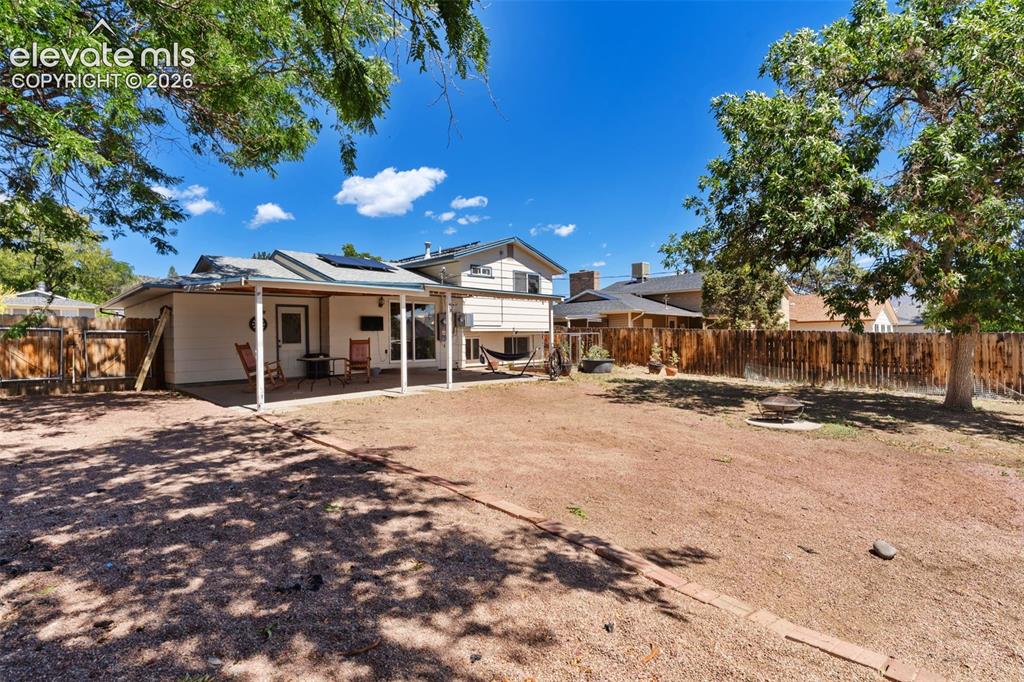 Image 34 of 36: Spacious backyard retreat featuring mature shade trees, expansive dirt and