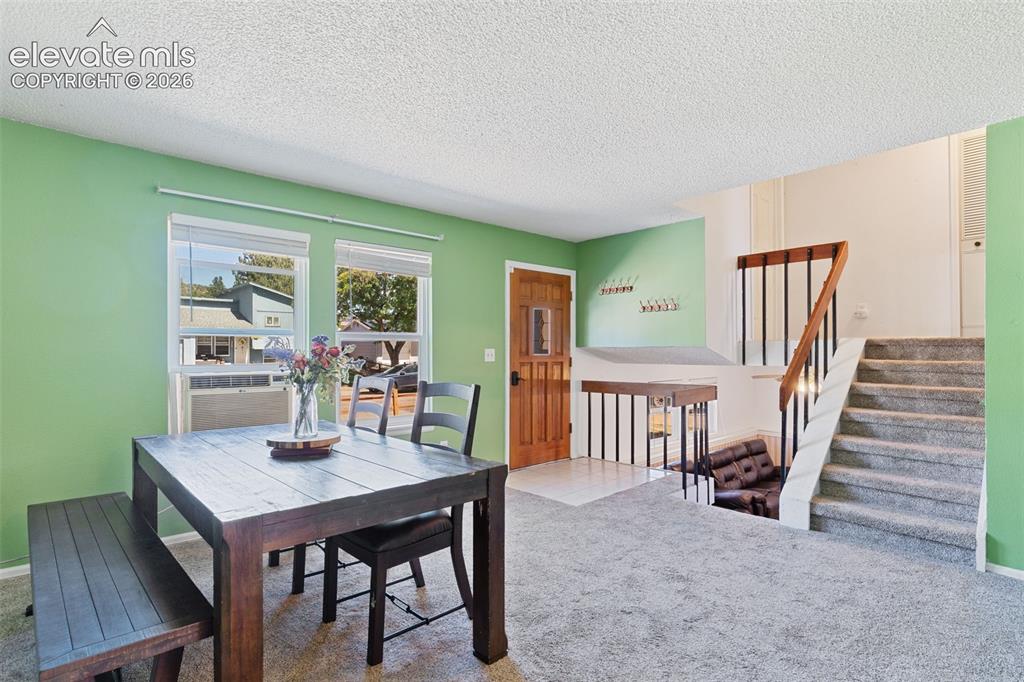 Image 6 of 36: Open concept living area with natural light, featuring a built-in staircase