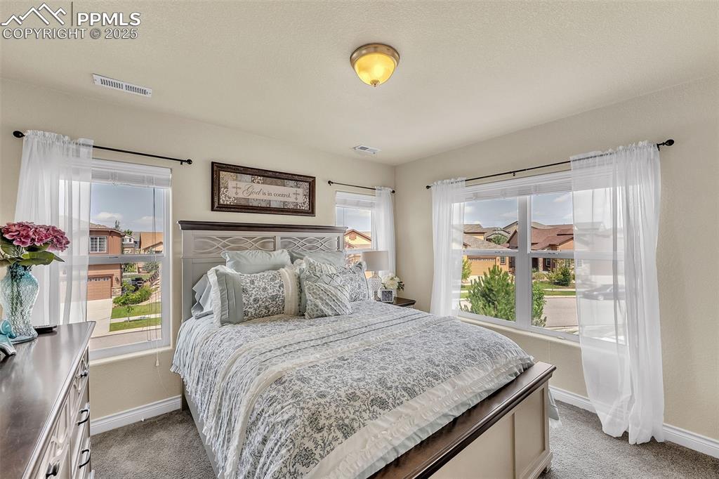 Image 21 of 40: Second bedroom with large windows and lots of light