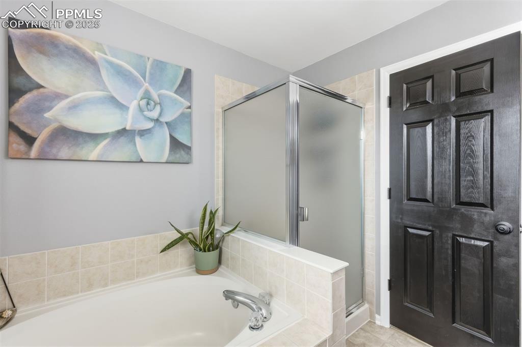 Image 20 of 46: Primary en suite bathroom with soaking tub & shower.