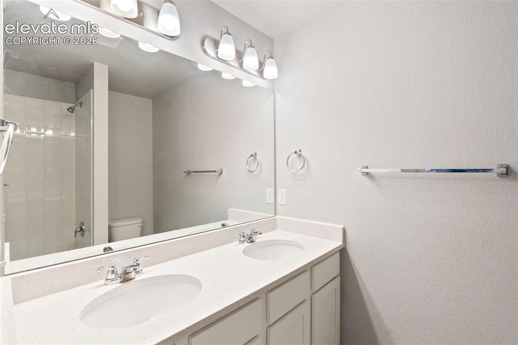 Image 13 of 26: Hall bathroom with double vanities with quartz countertops