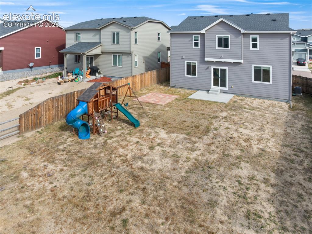Image 19 of 26: Large, Fenced back yard with playset.