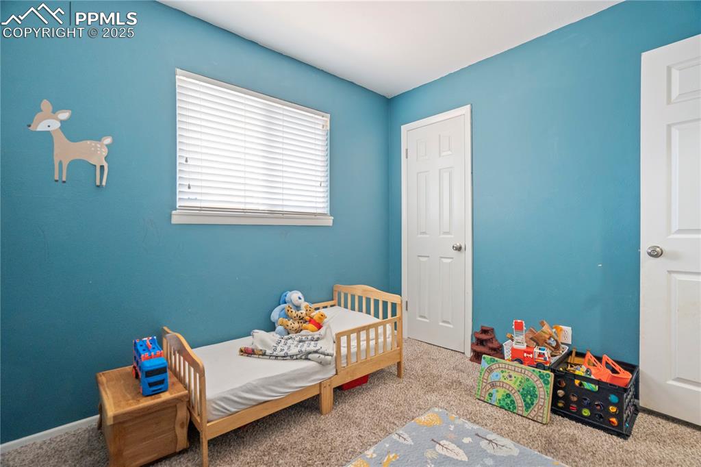 Image 14 of 22: Carpeted bedroom featuring a nursery area
