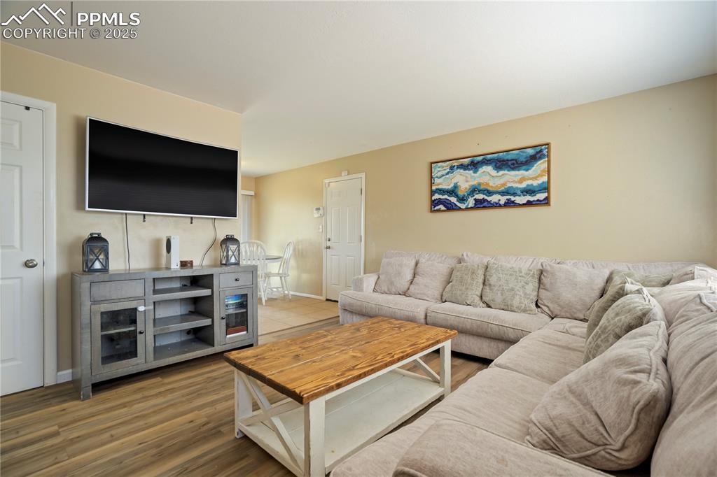 Image 4 of 22: Living room with wood finished floors and baseboards