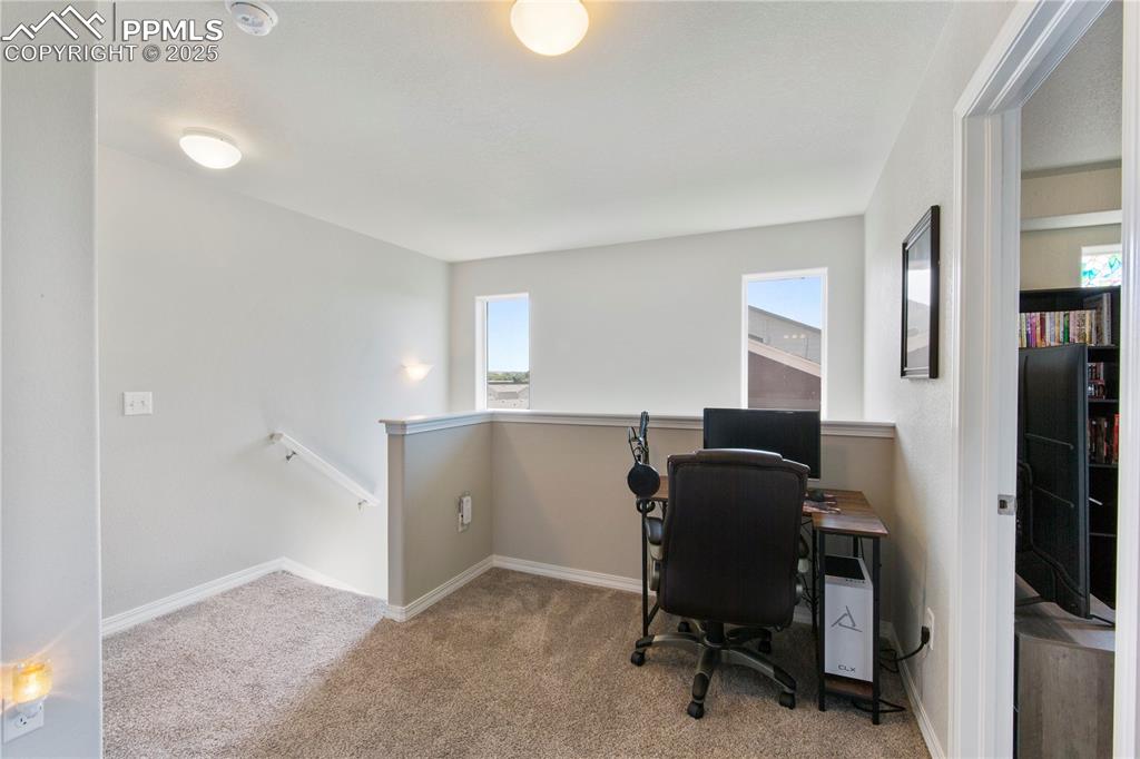 Image 15 of 36: Loft area at top of stairs on upper level used as an office.