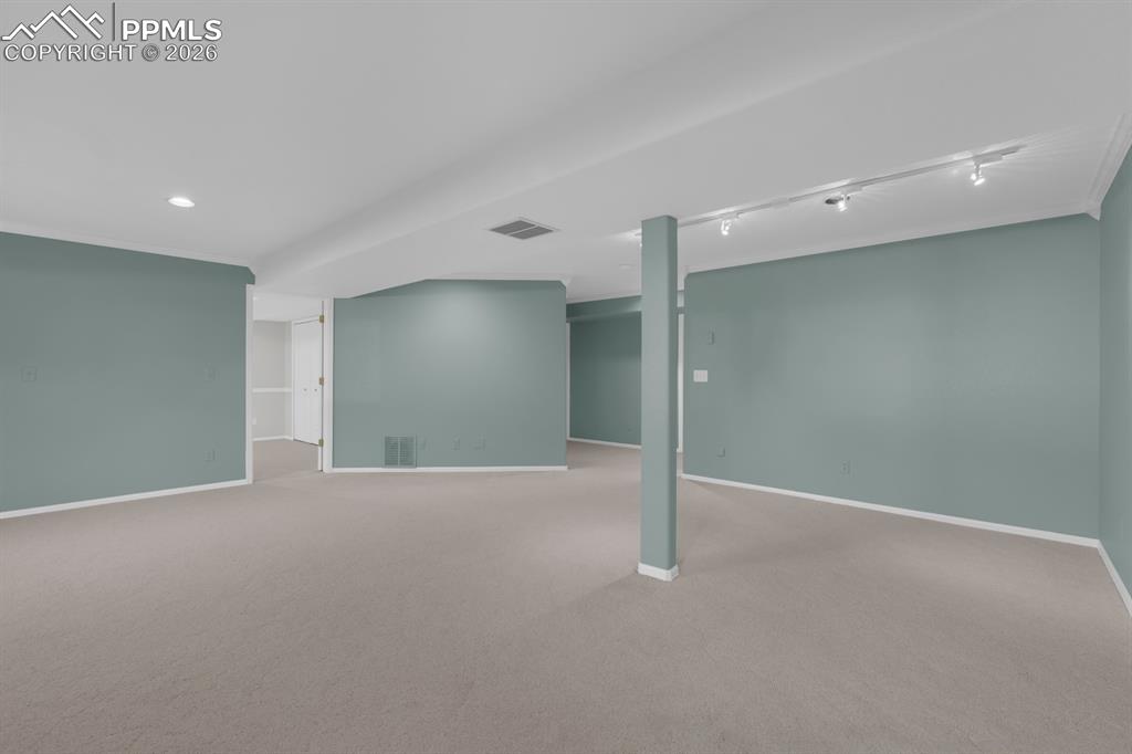 Image 29 of 43: Finished basement featuring track lighting