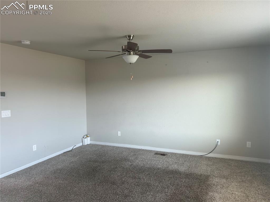 Image 3 of 10: Spare room featuring a ceiling fan, carpet flooring, and a smoke detector