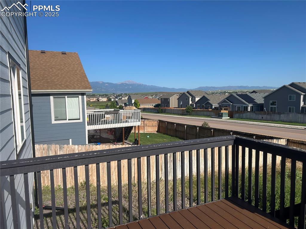 Image 4 of 10: Wooden terrace featuring a residential view, a fenced backyard, and a mount