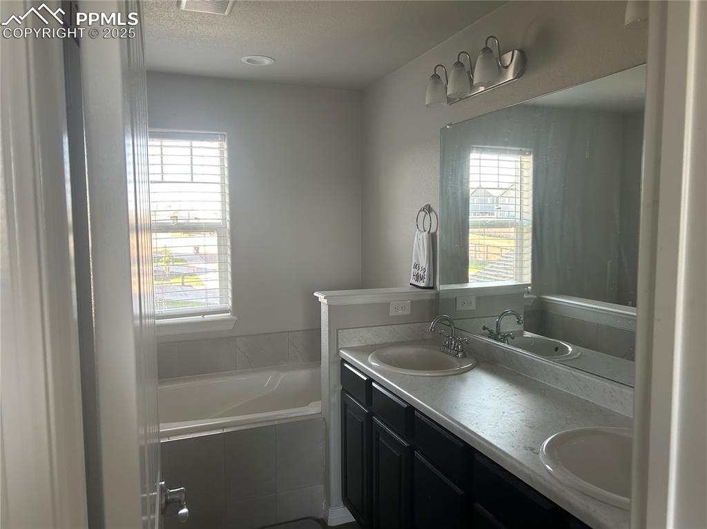 Image 6 of 10: Bathroom with healthy amount of natural light, a garden tub, double vanity,