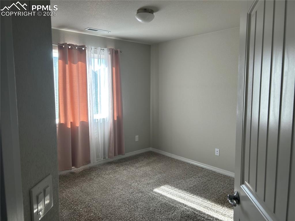 Image 7 of 10: Carpeted empty room with baseboards and a textured ceiling