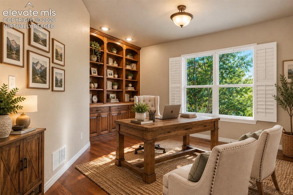 Image 24 of 50: VIRTUALLY STAGED - OFFICE WITH BUILT-IN SHELVES AND PLANTATION SHUTTERS