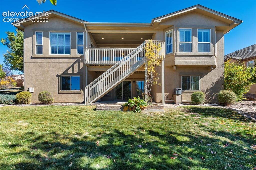 Image 40 of 50: Rear elevation featuring a stucco exterior, an elevated wood deck with stai