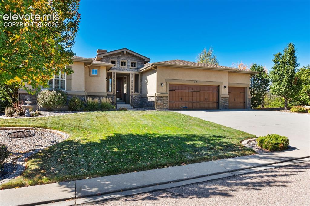Image 44 of 50: Exterior featuring stucco siding, stone veneer accents, multi-car garage wi