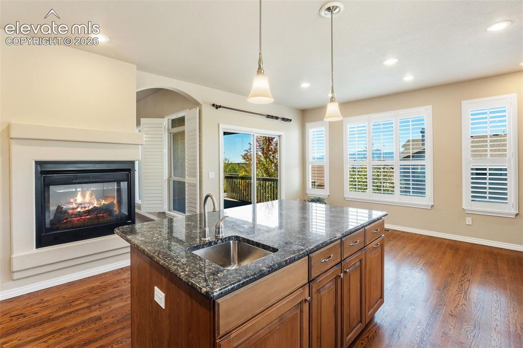 Image 6 of 50: Kitchen featuring a stone-topped island with an integrated stainless steel