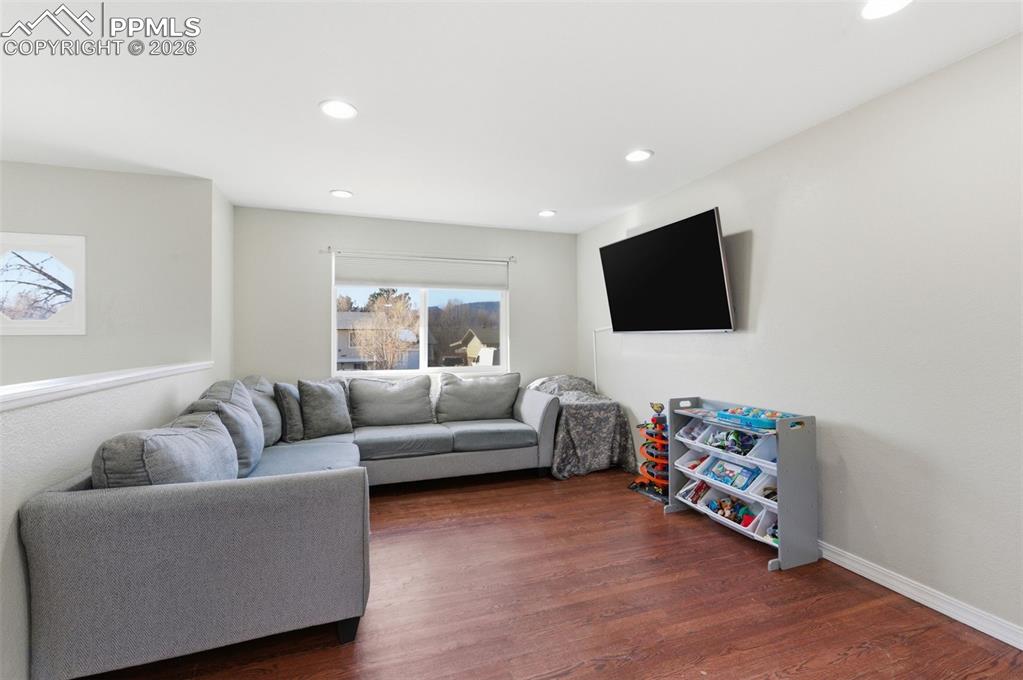 Image 13 of 50: Living area featuring dark wood-type flooring and recessed lighting