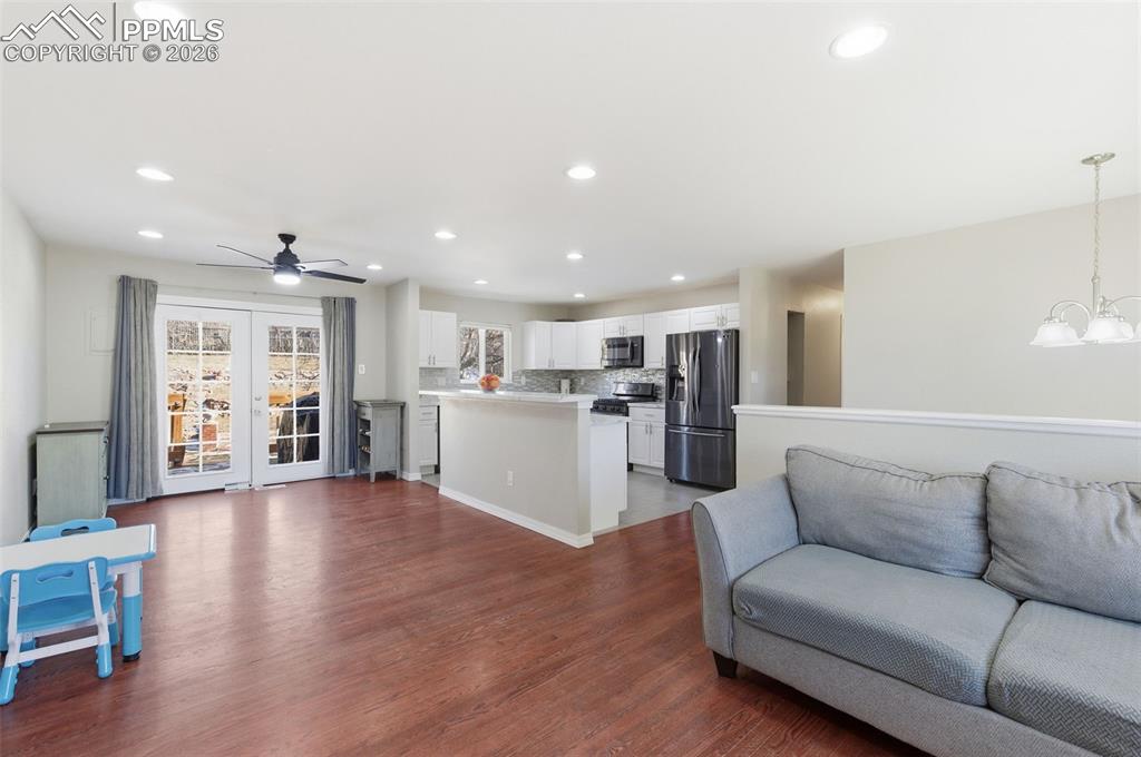 Image 14 of 50: Living area with french doors, dark wood-type flooring, a chandelier, and a