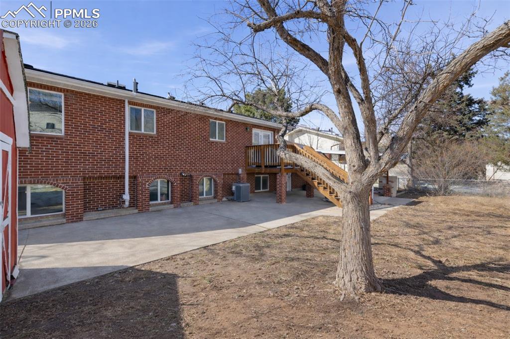 Image 37 of 50: Rear view of property featuring brick siding and a deck