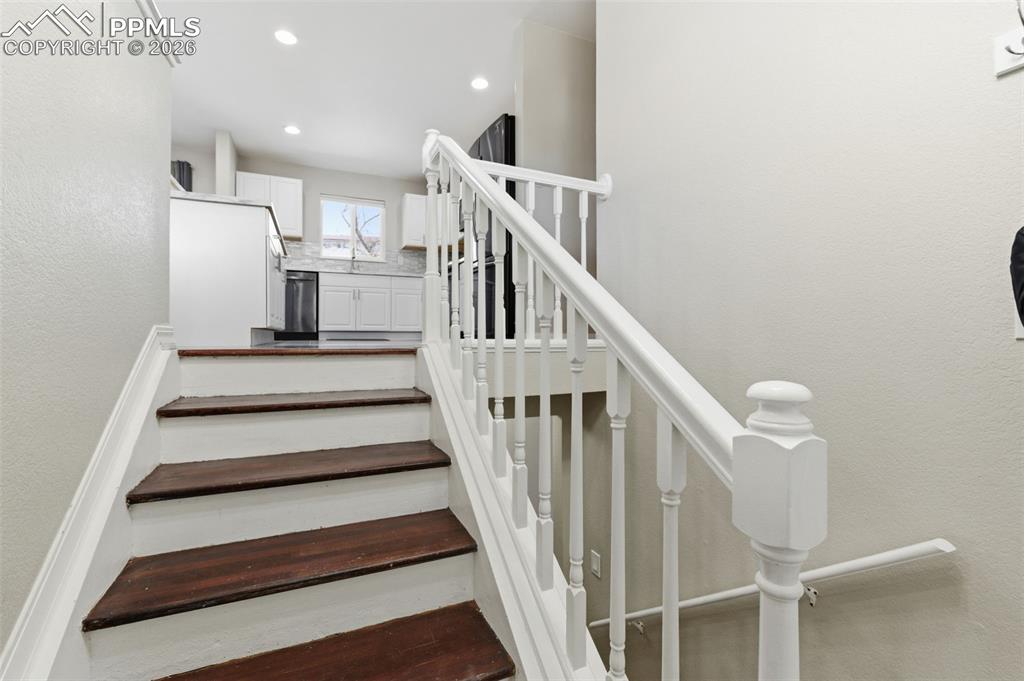 Image 5 of 50: Staircase with a textured wall and recessed lighting