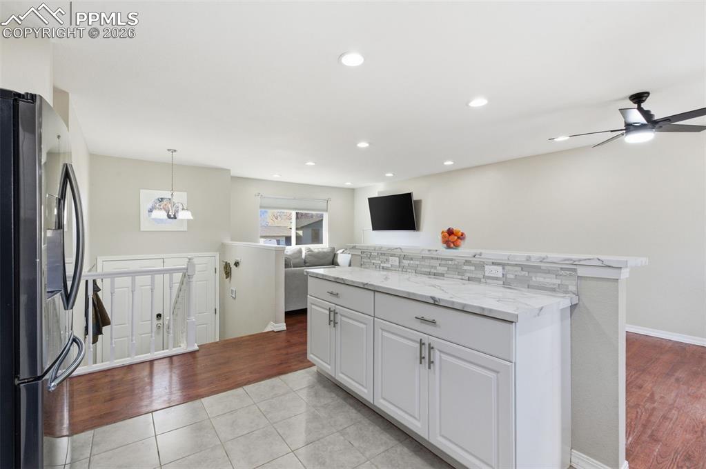 Image 9 of 50: Kitchen featuring stainless steel fridge, open floor plan, light tile patte