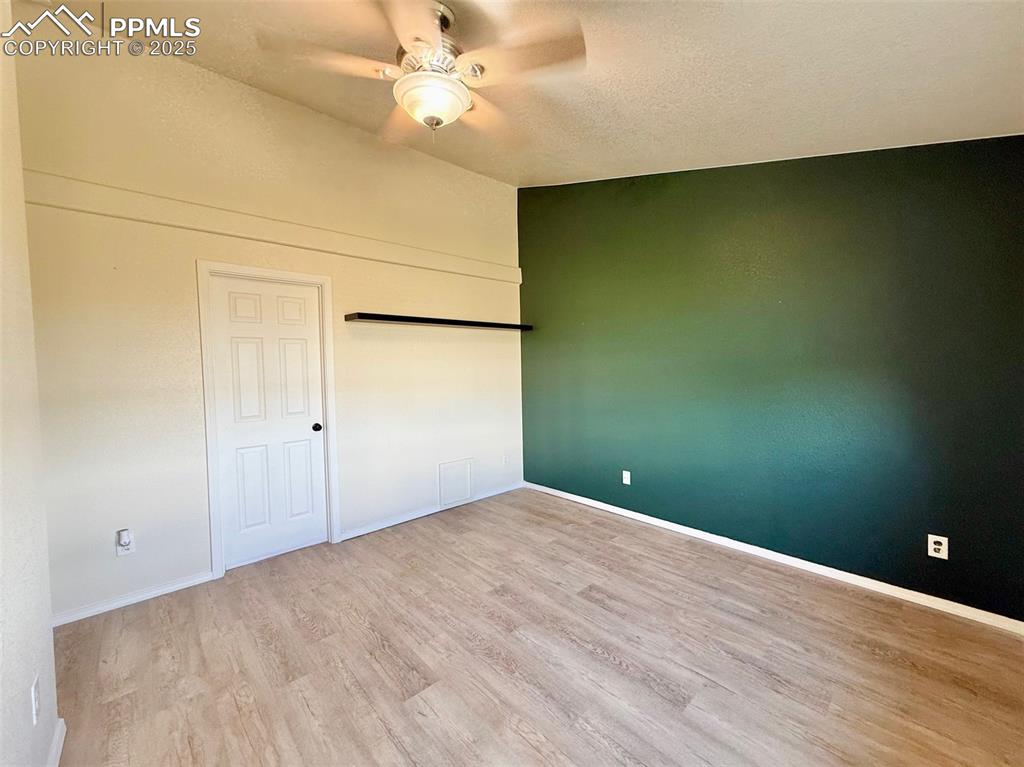 Image 13 of 37: Primary bedroom featuring light wood-style flooring, a ceiling fan, and a t