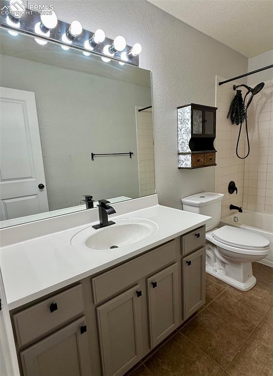 Image 20 of 37: Full bath with a textured wall, vanity, shower / washtub combination,  tile