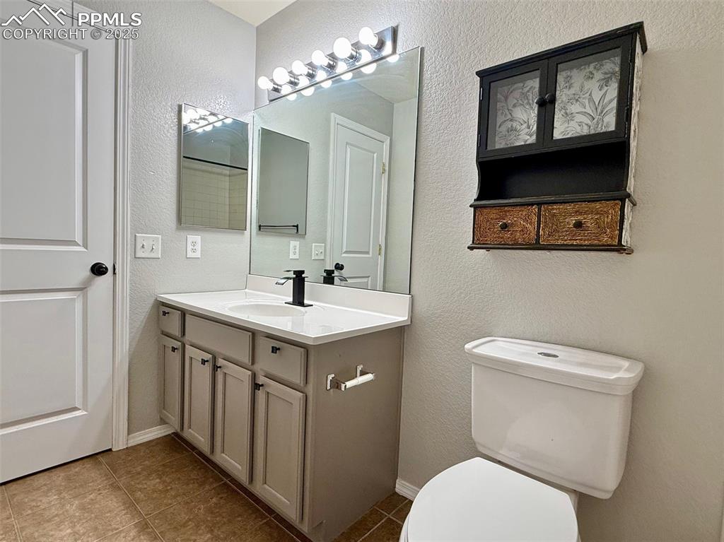 Image 21 of 37: Bathroom with a textured wall, vanity, and tile patterned floors