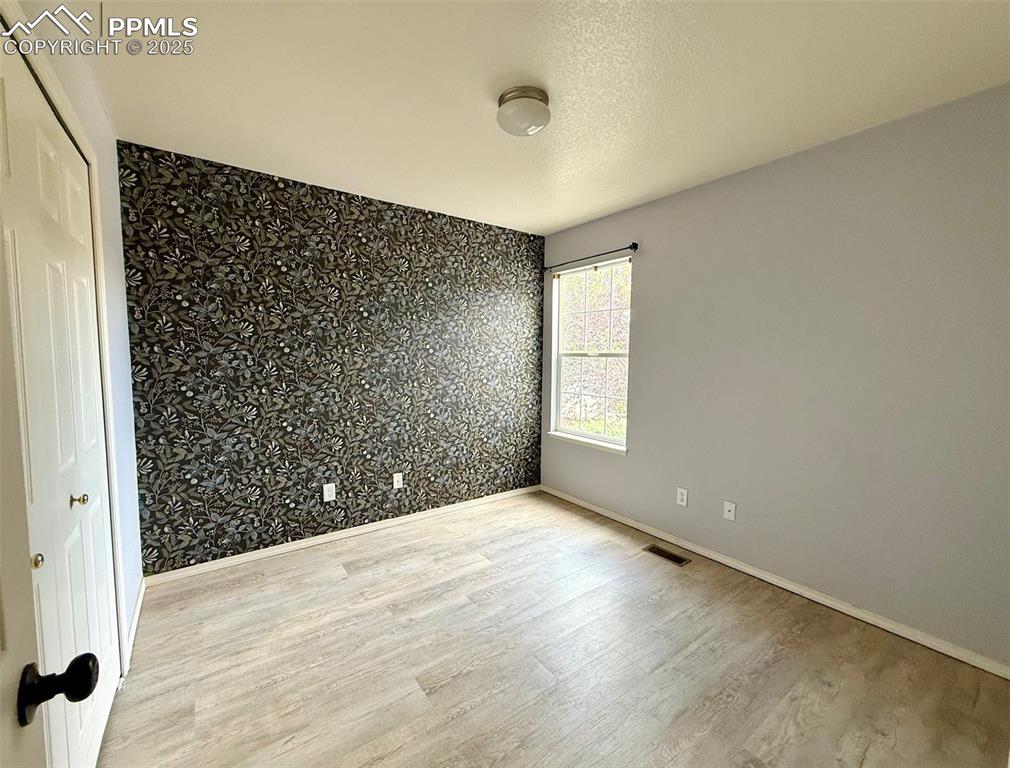 Image 22 of 37: Unfurnished room with light wood finished floors, a textured ceiling, and a