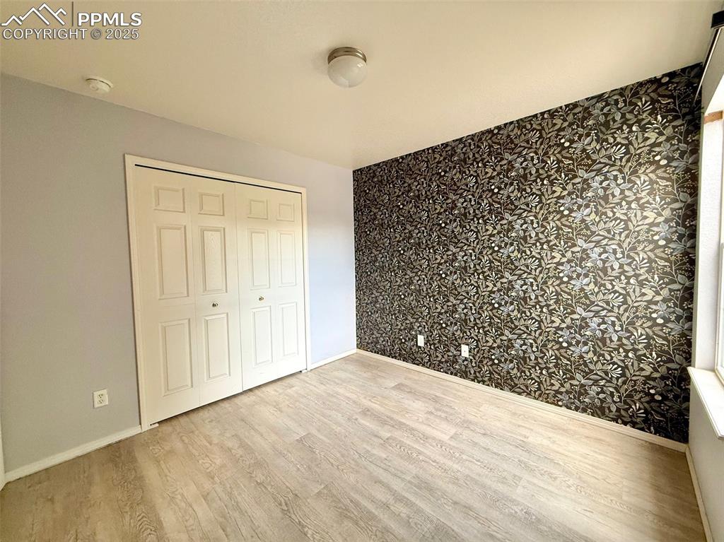 Image 23 of 37: Unfurnished bedroom with light wood-style flooring and a closet