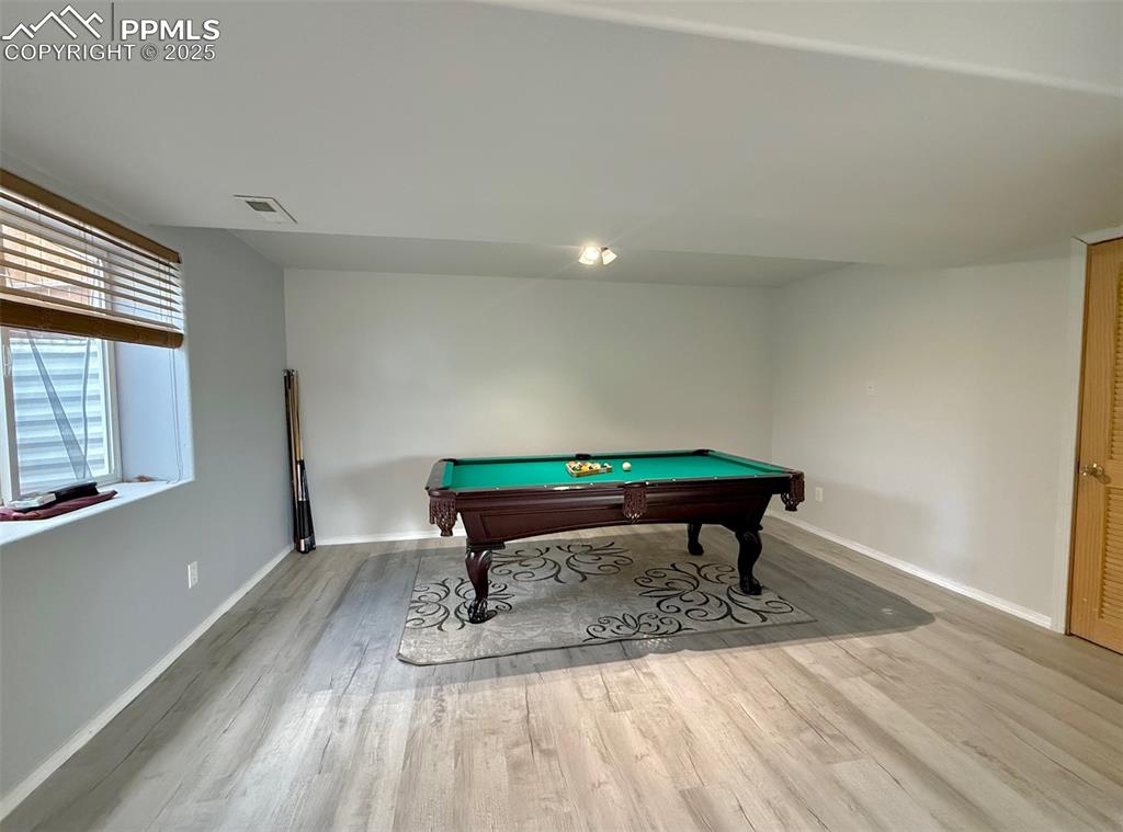 Image 24 of 37: Recreation room with pool table and light wood finished floors