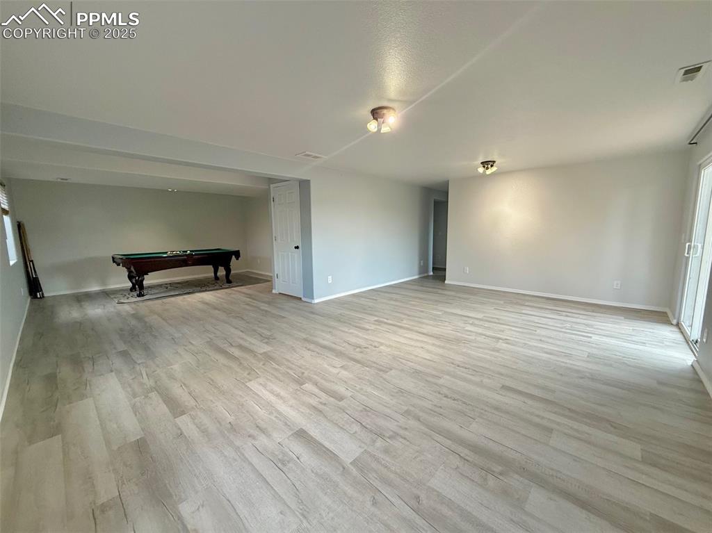 Image 26 of 37: Unfurnished room featuring billiards, plenty of natural light, and light wo