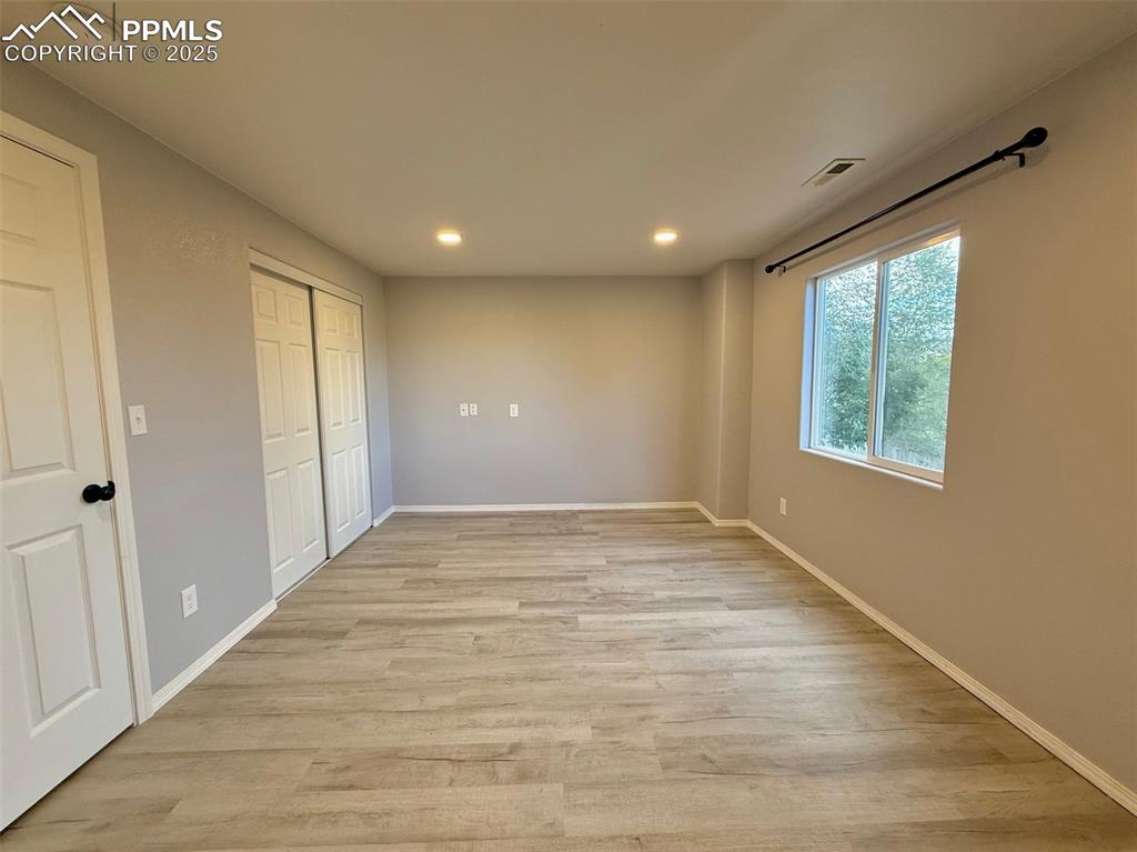 Image 28 of 37: Unfurnished bedroom featuring light wood-style flooring, a closet, and rece