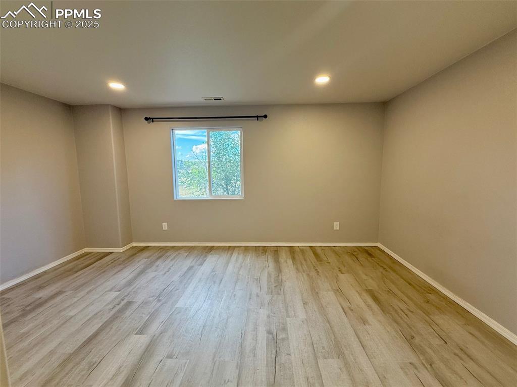 Image 29 of 37: Empty room with light wood-style floors and recessed lighting