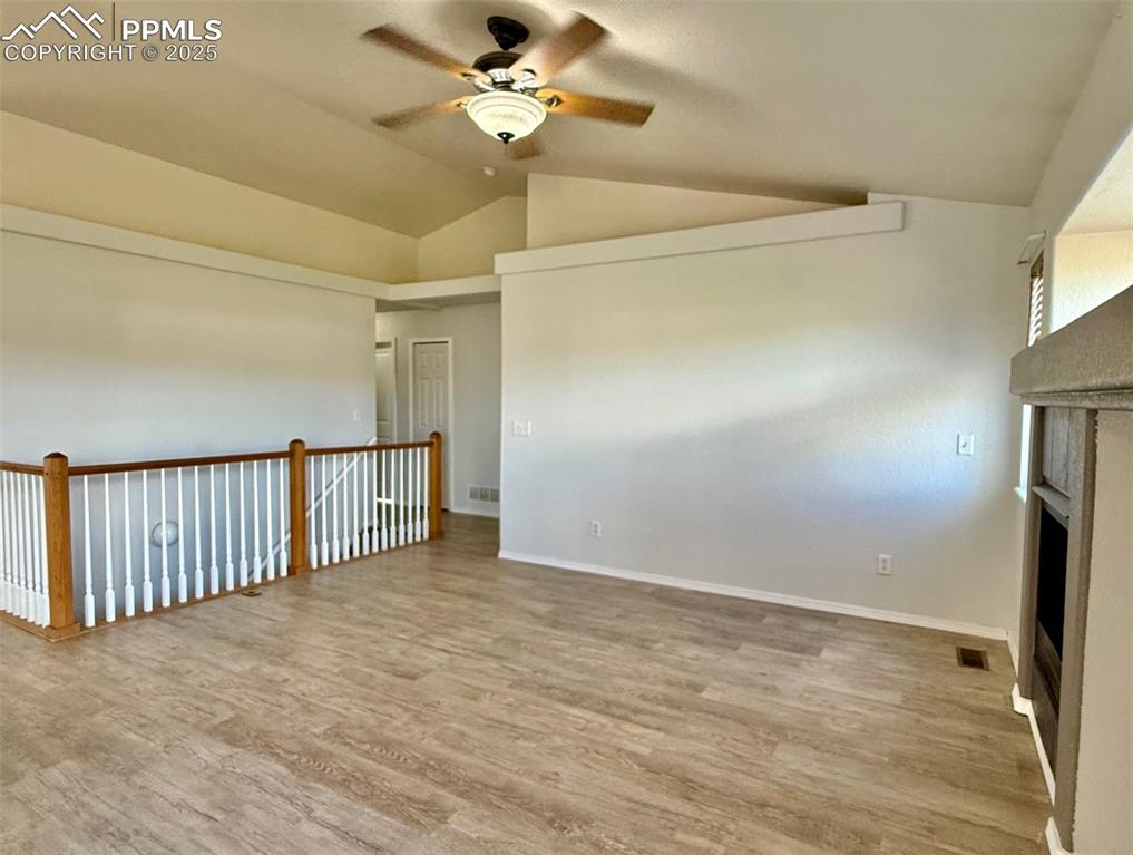 Image 8 of 37: Unfurnished living room with light wood-style floors, lofted ceiling, a fir