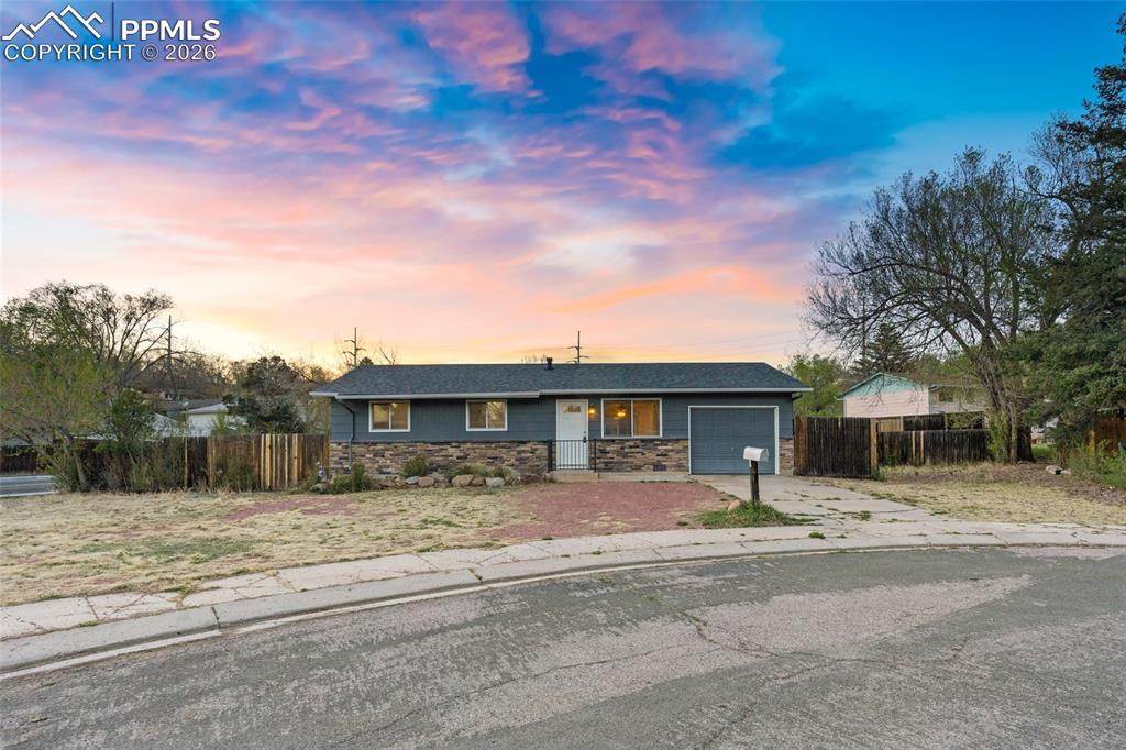 Image 1 of 19: Single story home featuring stone siding, concrete driveway, and a garage
