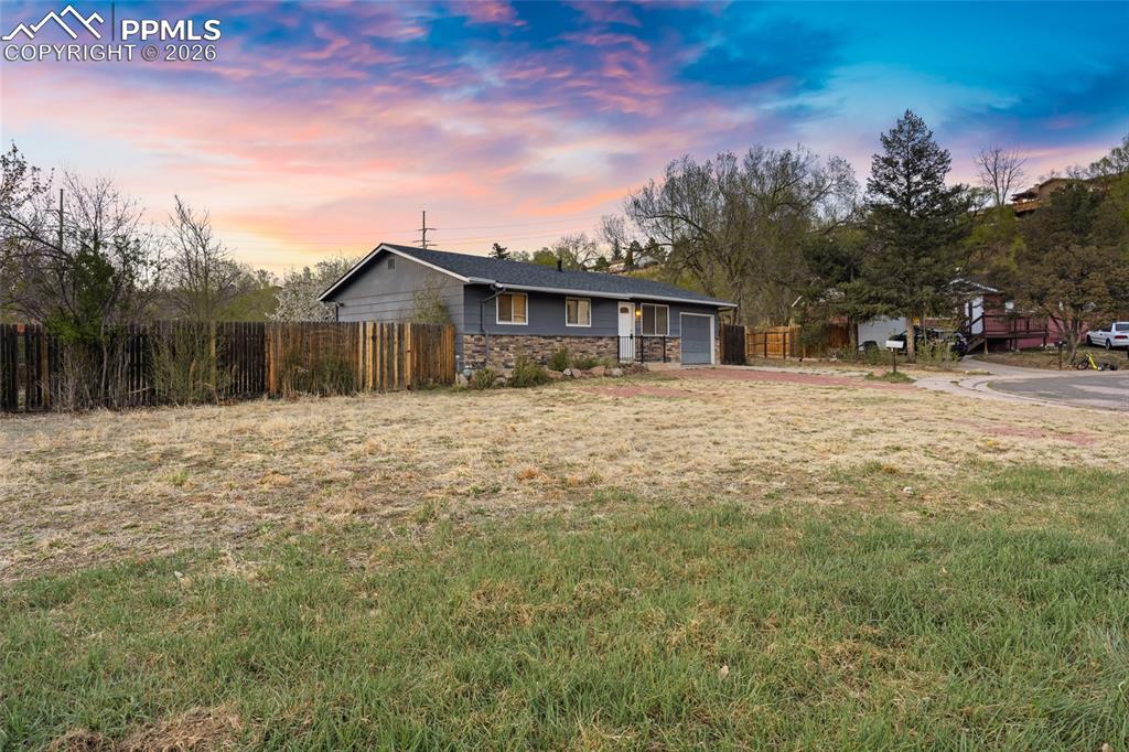 Image 3 of 19: Ranch-style home with stone siding, driveway, and an attached garage