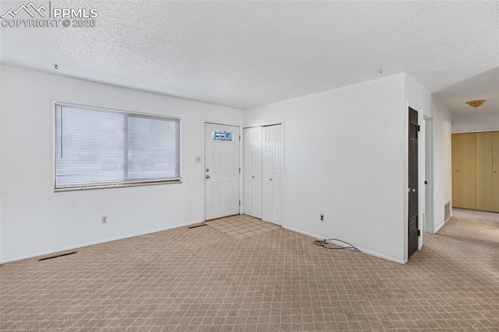 Image 8 of 19: Foyer entrance featuring carpet and a textured ceiling