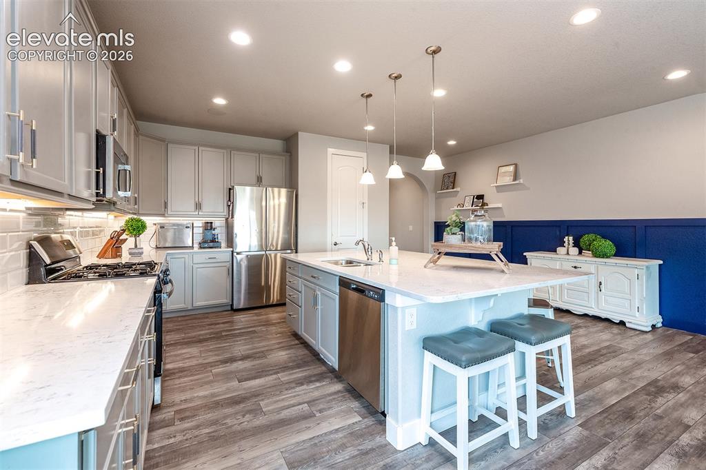 Image 12 of 43: Modern kitchen featuring  wood laminate flooring, stainless steel appliance