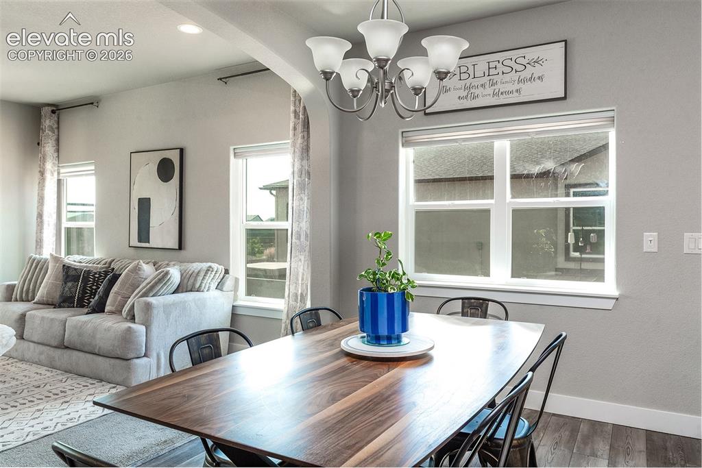 Image 14 of 43: Dining area featuring a wood-finish table, a five-light chandelier, and mul