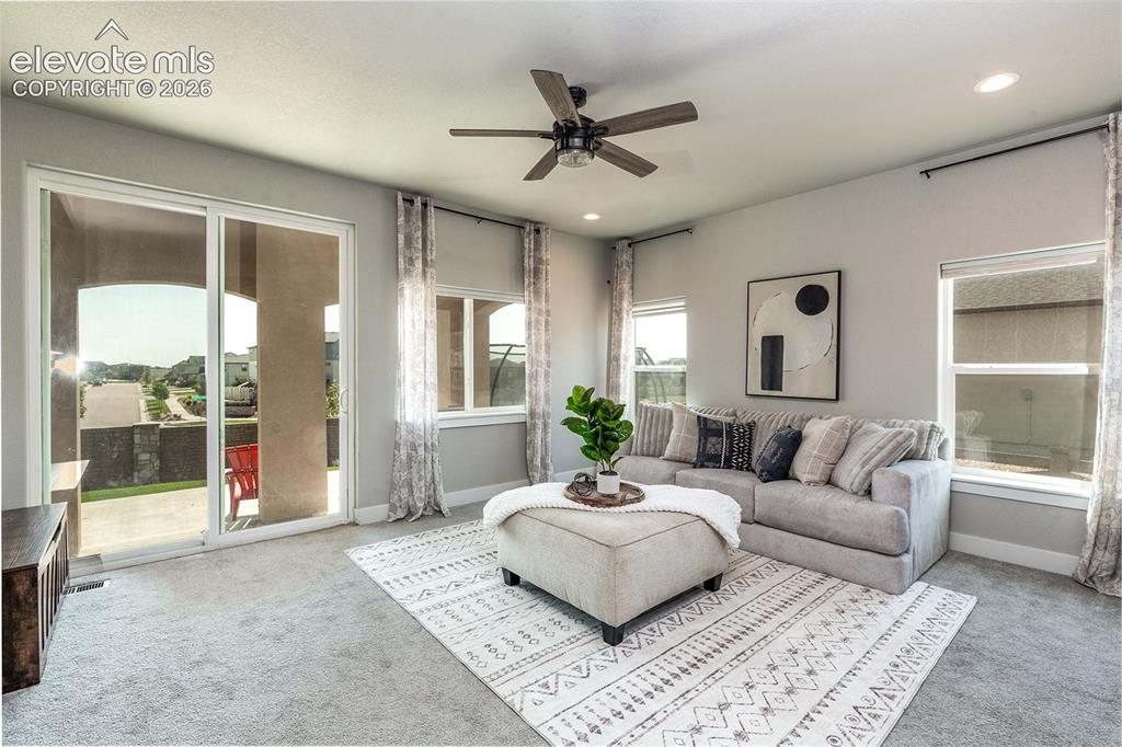 Image 16 of 43: Sliding glass door to an outdoor patio, multiple windows, recessed lighting