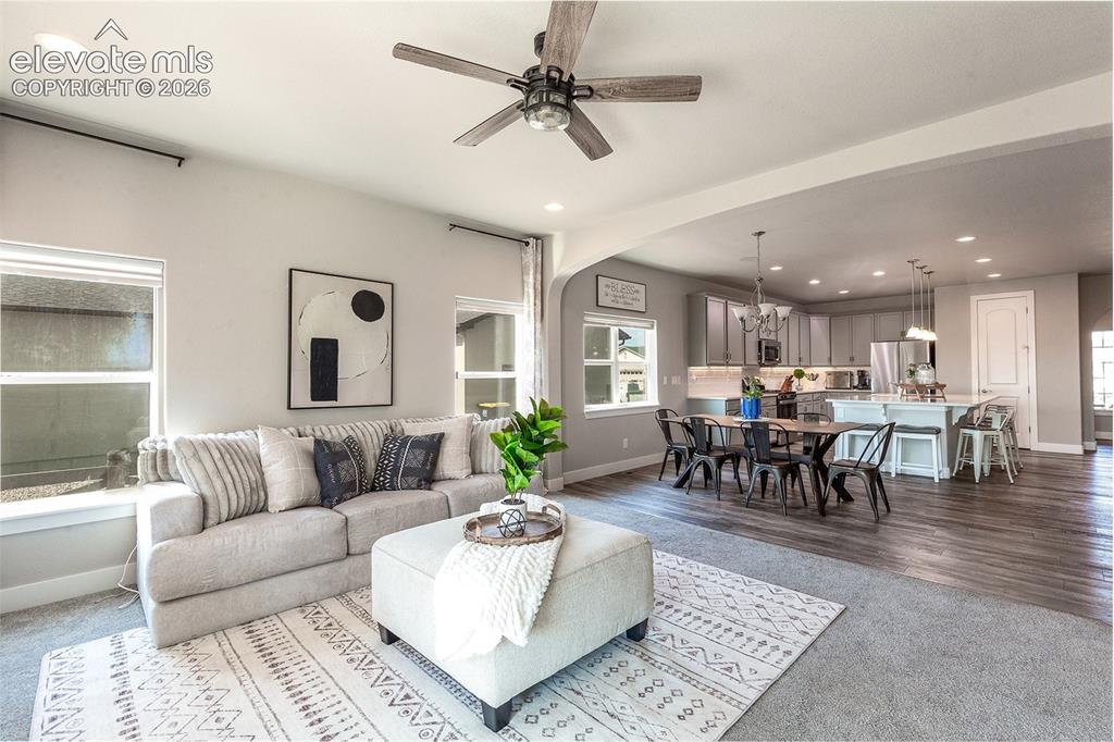 Image 17 of 43: Open-concept living area featuring a ceiling fan, recessed lighting, and la