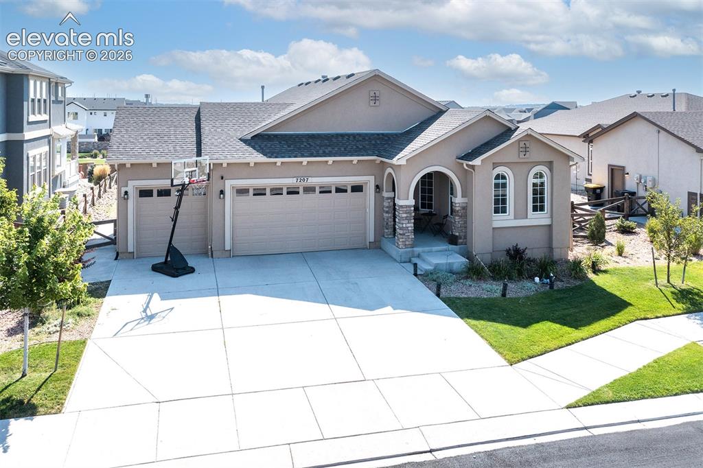 Image 2 of 43: Stucco exterior with stone accents, arched entryway, two-car garage, concre